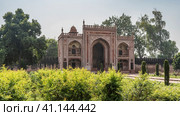 The building in the tomb of Itmad-Ud-Daulah complex is built of red sandstone, decorated with white ornaments. Arches and domes are visible. There is a wall around the perimeter of the garden. Agra (2022 год). Стоковое фото, фотограф Вера Ивановна Кубарева / Фотобанк Лори