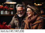 Happy and loving middle aged couple on a romantic date in a cafe in winter. Стоковое AI-изображение, AI-художник Светлана Лажко / Фотобанк Лори