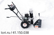 Snowblower removes snow, a man cleans the yard outside. Стоковое фото, фотограф Igor Skripachev / Фотобанк Лори