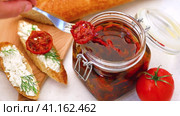 The process of taking out sun-dried tomatoes from a glass jar and making sandwiches. Стоковое видео, видеограф Сергей Чайко / Фотобанк Лори