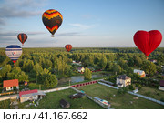 Воздушные шары пролетают над частными домами в Подмосковье (2022 год). Редакционное фото, фотограф Елена Коромыслова / Фотобанк Лори