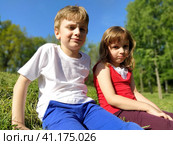 Boy and girl, brother and sister. Children with displeased faces are looking at the camera. Fatigue and caprice are visible on the face. A boy in a white T-shirt, girl in a red Tshirt with white lace. Стоковое фото, фотограф Юлия Петровская / Фотобанк Лори