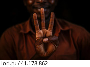 African man shows three fingers. Стоковое AI-изображение, AI-художник Поликарпов Владимир Владимирович / Фотобанк Лори
