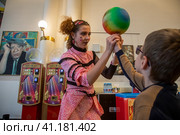Артист цирка выступает перед зрителями в фойе Московского Цирка Никулина на Цветном бульваре в городе Москве перед началом основного представления, Россия (2023 год). Редакционное фото, фотограф Николай Винокуров / Фотобанк Лори