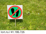 Photo of warning sign, which is meaning that walking on grass is strictly prohibited. The sign is installed in the park on the edge of the lawn area. Фотография предупреждающего знака, который означает, что ходить по траве строго запрещено. Знак установлен в парке на краю газонной зоны. Стоковое фото, фотограф Дмитрий Березнев / Фотобанк Лори