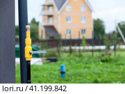 Трубопровод природного газа с закрытым краном на фоне коттеджа. Стоковое фото, фотограф Кекяляйнен Андрей / Фотобанк Лори