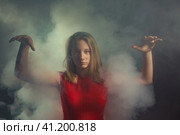 Девушка с красном платье окутана дымом. Стоковое фото, фотограф Юрий Викулин / Фотобанк Лори