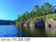 Evening view of the rocky coast of Valaam island overgrown with pine trees. Стоковое фото, фотограф Михаил Аккуратoв / Фотобанк Лори