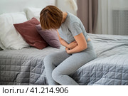 Stomach ache, symptoms of gastritis or pancreatitis, woman with abdominal pain suffering at home. Стоковое фото, фотограф Станислав Тарко / Фотобанк Лори