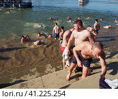 Sremska Mitrovica, Serbia, January 19, 2022. Christian holiday Epiphany. Mass bathing of people in the river in winter. Epiphany bathing. Редакционное фото, фотограф Юлия Петровская / Фотобанк Лори