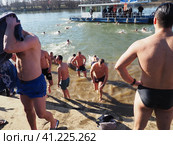 Sremska Mitrovica, Serbia, January 19, 2022. Christian holiday Epiphany. Mass bathing of people in the river in winter. Epiphany bathing. Редакционное фото, фотограф Юлия Петровская / Фотобанк Лори
