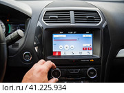 The male driver is adjusting the volume of  the car audio system. Водитель-мужчина регулирует громкость автомобильной аудиосистемы. Стоковое фото, фотограф Дмитрий Березнев / Фотобанк Лори