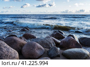 Photo of the rocks on the beach of the finnish bay in St. Petersburg. Choppy sea and a cloudy sky on the background. Фотография скал на пляже Финского залива в Санкт-Петербурге. Неспокойное море и облачное небо на заднем плане. Стоковое фото, фотограф Дмитрий Березнев / Фотобанк Лори