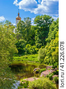 Midsummer in a dense park with a church and a pond (2009 год). Редакционное фото, фотограф Сергей Бочаров / Фотобанк Лори