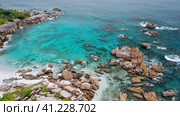 Aerial drone 4k forward flight towards hidden idyllic tropical beach Anse Marron at La Digue island. Exotic paradise nature of Seychelles. Стоковое фото, фотограф Igor Tichonow / Фотобанк Лори