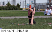 Russia, Nizhny Novgorod, VUO, Volga embankment 43 06.05.2021. A young woman is doing yoga on the street, in a beautiful meadow in summer. High quality FullHD footage. Редакционное видео, видеограф Egor Sarantstv / Фотобанк Лори