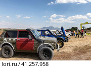 Racing off-road vehicles are lined up for display and inspection before the competition against the backdrop of Mount Beshtau (2023 год). Редакционное фото, фотограф Сергей Сергеев / Фотобанк Лори