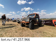 SUVs with specially reinforced suspension stand in the field before the start of the rally (2023 год). Редакционное фото, фотограф Сергей Сергеев / Фотобанк Лори