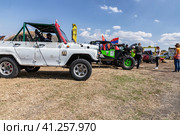 SUVs with specially reinforced suspension stand in the field before the start of the rally (2023 год). Редакционное фото, фотограф Сергей Сергеев / Фотобанк Лори