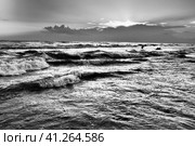Waves with foam. Beautiful sunset. Foamy waves roll over the sandy shore. Vityazevo, Anapa, Black Sea. Tourist mecca, health resort. Colorful clouds in the evening sky. The rays reflect off the water. Стоковое фото, фотограф Юлия Петровская / Фотобанк Лори