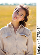 Young beautiful brunette model in a beige dress posing against the background of a mowed wheat field. Стоковое фото, фотограф Андрей Аркуша / Фотобанк Лори