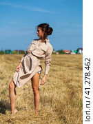 Young beautiful brunette model in a beige dress posing against the background of a mowed wheat field. Стоковое фото, фотограф Андрей Аркуша / Фотобанк Лори