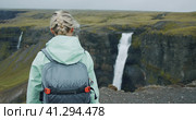 Woman with backpack walking towards Haifoss waterfall in iceland highland. Стоковое фото, фотограф Igor Tichonow / Фотобанк Лори