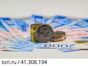 Russian banknotes and coins. A handful of coins on new Russian banknotes in denominations of 2000 and 200 rubles. Стоковое фото, фотограф Леонид Еремейчук / Фотобанк Лори