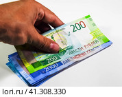 A bundle of money in his hand. Russian rubles. Banknotes of 200 and 2000 rubles. Стоковое фото, фотограф Леонид Еремейчук / Фотобанк Лори