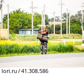 Hitchhiking. Girl auto-stopper. The girl with the backpack stops the car. Voting on the track. (2017 год). Редакционное фото, фотограф Леонид Еремейчук / Фотобанк Лори