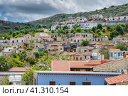 Panorama of Cyprus mountain village Lefkara. Authentic houses with red tiled roofs and white tanks for water over the mountains and cloudy sky. Панорама кипрской горной деревни Лефкара. Аутентичные дома с красными черепичными крышами и белыми резервуарами для воды над горами и облачным небом (2019 год). Стоковое фото, фотограф Дмитрий Березнев / Фотобанк Лори