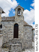 One of the central streets of Kato Lefkara. Chapel with the bell on the top of stony house against blue cloudy sky. Одна из центральных улиц Като-Лефкара. Часовня с колоколом на крыше каменного дома на фоне голубого облачного неба. (2019 год). Стоковое фото, фотограф Дмитрий Березнев / Фотобанк Лори