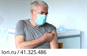 Elderly Man in Face Mask getting Covid Vaccine. Doctor giving Injection to senior Man at Hospital. Virus, COVID-2019 Flu protection. Vaccination of old Patient in Clinic during Coronavirus pandemic. Стоковое видео, видеограф Марина Демидюк / Фотобанк Лори