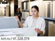 woman is considering MDF boards for internal insulation of residential premises. Стоковое фото, фотограф Яков Филимонов / Фотобанк Лори