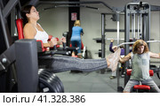 Caucasian woman doing leg raises on captains chair in gym. Стоковое фото, фотограф Яков Филимонов / Фотобанк Лори
