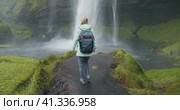 Woman enjoy beautiful Seljalandsfoss waterfall Iceland. Стоковое видео, видеограф Igor Tichonow / Фотобанк Лори
