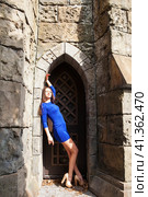 Portrait young beautiful brunette woman in blue dress posing against the backdrop of an old castle in the Gothic style. Стоковое фото, фотограф Андрей Аркуша / Фотобанк Лори