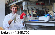 Skilled man lab technician in white coat and protective face mask working in food testing laboratory, provide testing services of pepper to support quality control. Стоковое видео, видеограф Яков Филимонов / Фотобанк Лори