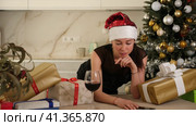 girl in santa hat is sitting in kitchen. She s upset. Стоковое видео, видеограф Яков Филимонов / Фотобанк Лори