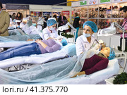 Cosmetologists perform a procedure to rejuvenate facial skin cosmetics Aravia at the festival of beauty Nevskie Berega in St. Petersburg 2012. Редакционное фото, фотограф Анна Кривицкая / Фотобанк Лори