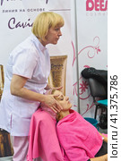 Cosmetologists perform a procedure to rejuvenate facial skin cosmetics Aravia at the festival of beauty Nevskie Berega in St. Petersburg 2012. Редакционное фото, фотограф Анна Кривицкая / Фотобанк Лори