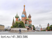 Москва, Россия. Солдат Росгвардии с ограждением в руках на фоне лобного места и Православного храма Василия Блаженного или собо́ра Покрова́ Пресвято́й Богоро́дицы на Красной площади Московского Кремля. Объект всемирного наследия ЮНЕСКО. На фоне виден Васильевский спуск. и район Балчуг. (2023 год). Редакционное фото, фотограф Сергей Никифоров-Гордеев / Фотобанк Лори