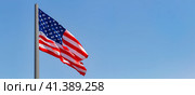 American flag waving in the wind against blue sky. Стоковое фото, фотограф Nobilior / Фотобанк Лори