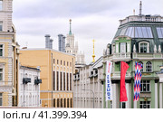 Москва, Россия, сентябрь 2023 года. Вид с Большого Каменного моста на квартал старинных красивых московских строений разнообразных стилей. На мосту размещены флаги в честь празднования дня города. Нет людей. Редакционное фото, фотограф Сергей Никифоров-Гордеев / Фотобанк Лори