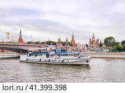 Москва, Россия, сентябрь 2023 года. Прогулочный речной теплоход проплывает по реке Москве на фоне парка Зарядье, Кремля и Большого Москворецкого моста. Редакционное фото, фотограф Сергей Никифоров-Гордеев / Фотобанк Лори