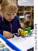 Kid girl 5 year old using constructor blocks and PC, technology homework. Child inventing robot in programming classroom, construct robotic toys. Learning robotics basics concept. Copy ad text space. Стоковое фото, фотограф Aleksandr Golubev / Фотобанк Лори