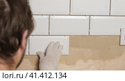 Male Worker Master Laying Ceramic Tiles on the Wall of Kitchen. Repairman Placing White Modern Tiles, Spreading Adhesive. Builder Installing Tile at Repair Renovation Work. Professional Tiling. 4K. Стоковое видео, видеограф Марина Демидюк / Фотобанк Лори