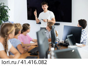 Young male teacher speaking to underage attendees of computer courses. Стоковое фото, фотограф Яков Филимонов / Фотобанк Лори