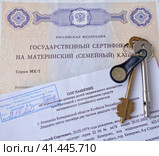 Государственный сертификат материнский (семейный) капитал, соглашение об определении размера долей недвижимого имущества и ключи от дверного замка (2023 год). Редакционное фото, фотограф Цибаев Алексей / Фотобанк Лори