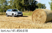 Vladimir Russia, September 04, 2021: Jili Atlas Pro car on a field with hay circles. Стоковое фото, фотограф Igor Skripachev / Фотобанк Лори